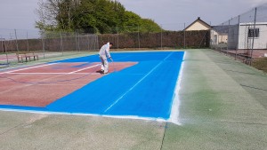 application de peinture sur le terrain de tennis
